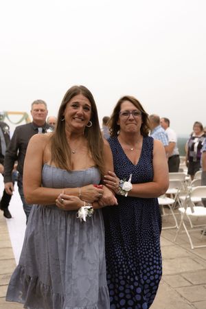 Wedding guests in formal attire gathered on an outdoor stone patio.