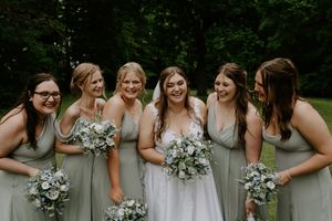 Wedding party members share joyful moment together during outdoor photo session.