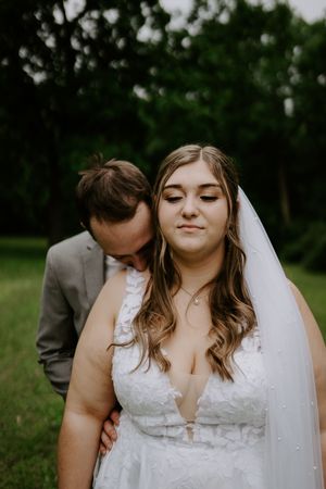 Intimate wedding portraits showcase tender moments between couple in natural setting.