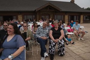 Panoramic view of wedding venue with stone building and seated guests.