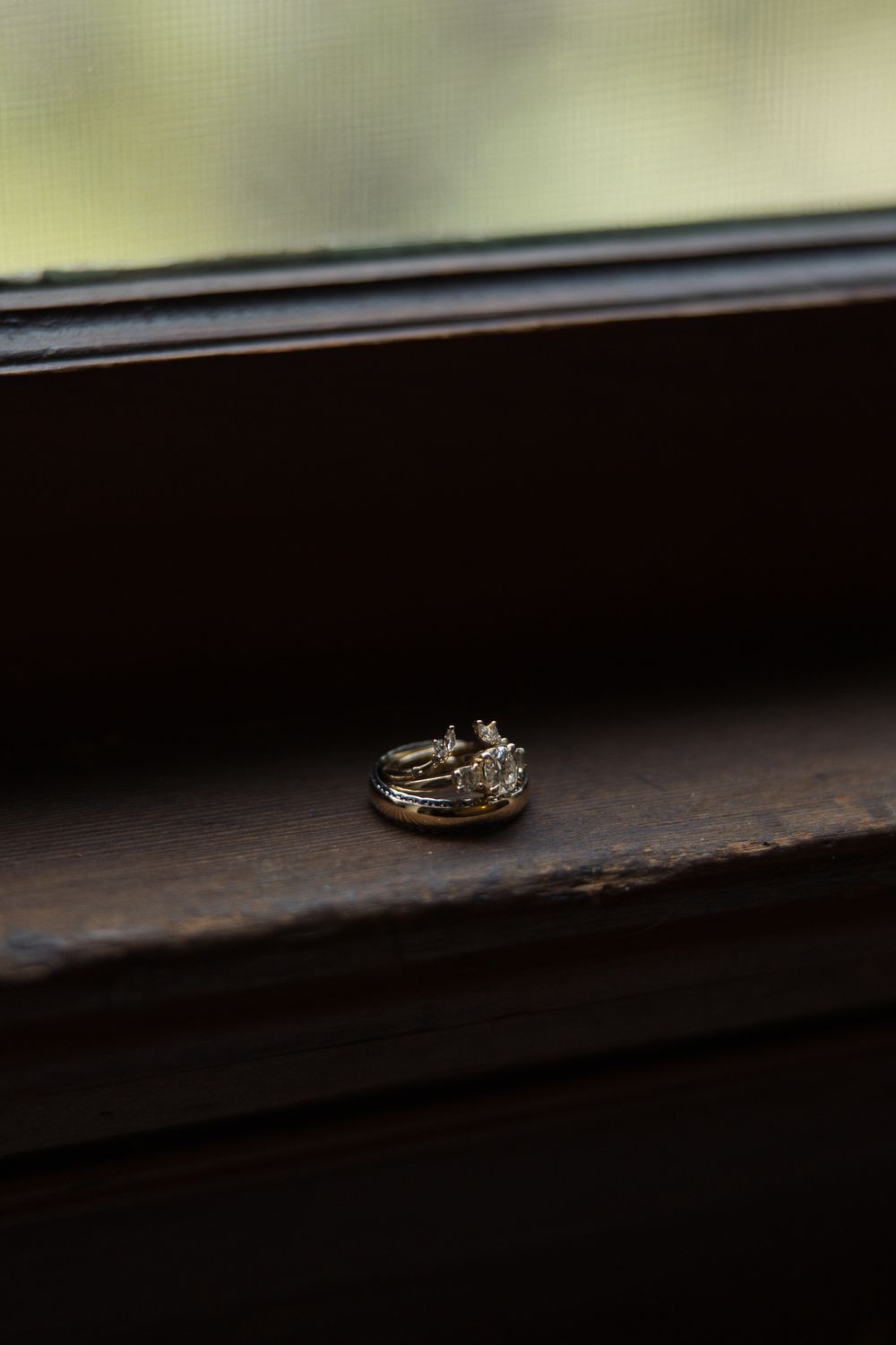 Wedding rings placed on a windowsill with soft window light