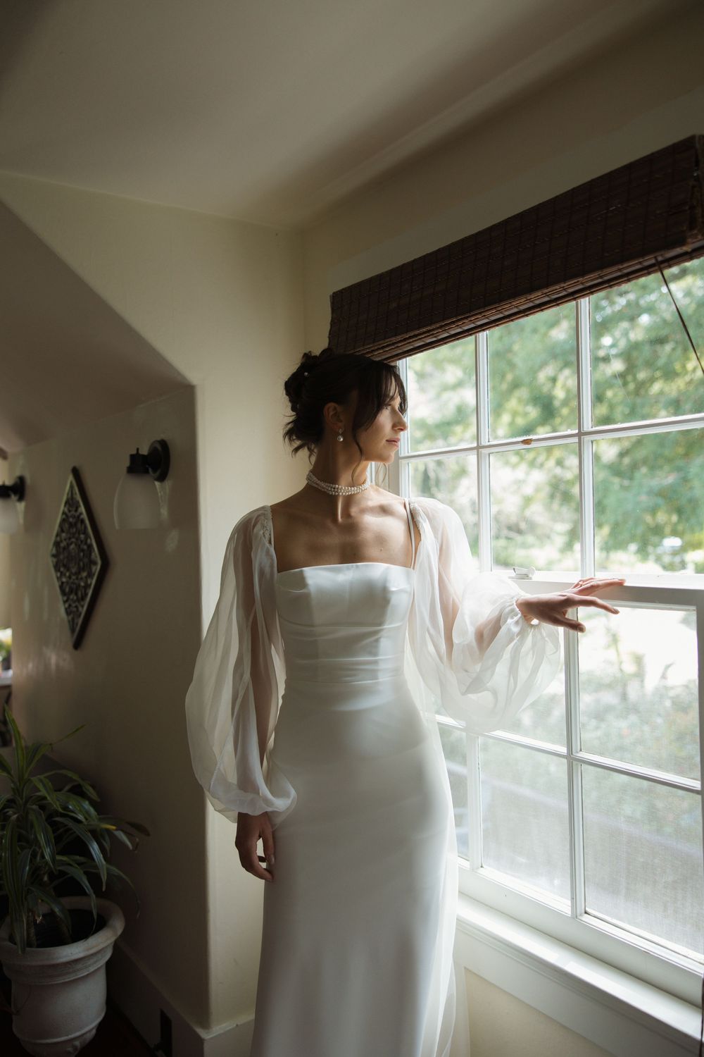 Bridal portrait of bride looking out the window in soft natural light