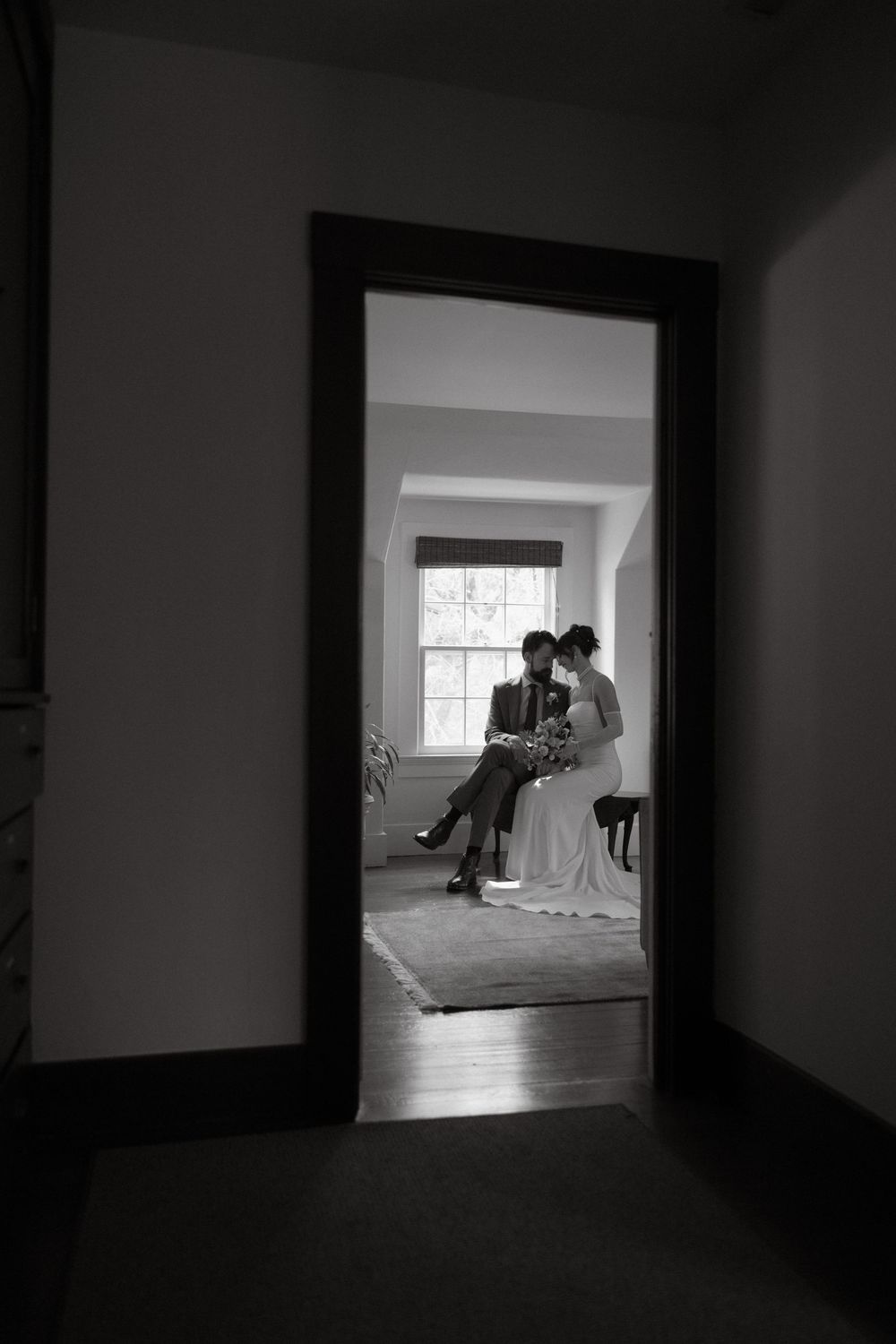 Black and white photo through a doorway of couple sharing a quiet moment together
