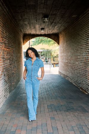 A progression of photos showing someone walking through a brick tunnel in denim overalls from different angles.