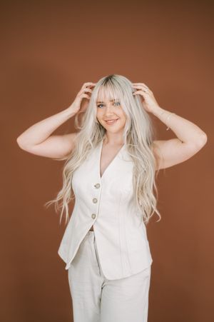 Fashion model in white button-up vest poses playfully against brown background showing different poses and expressions.