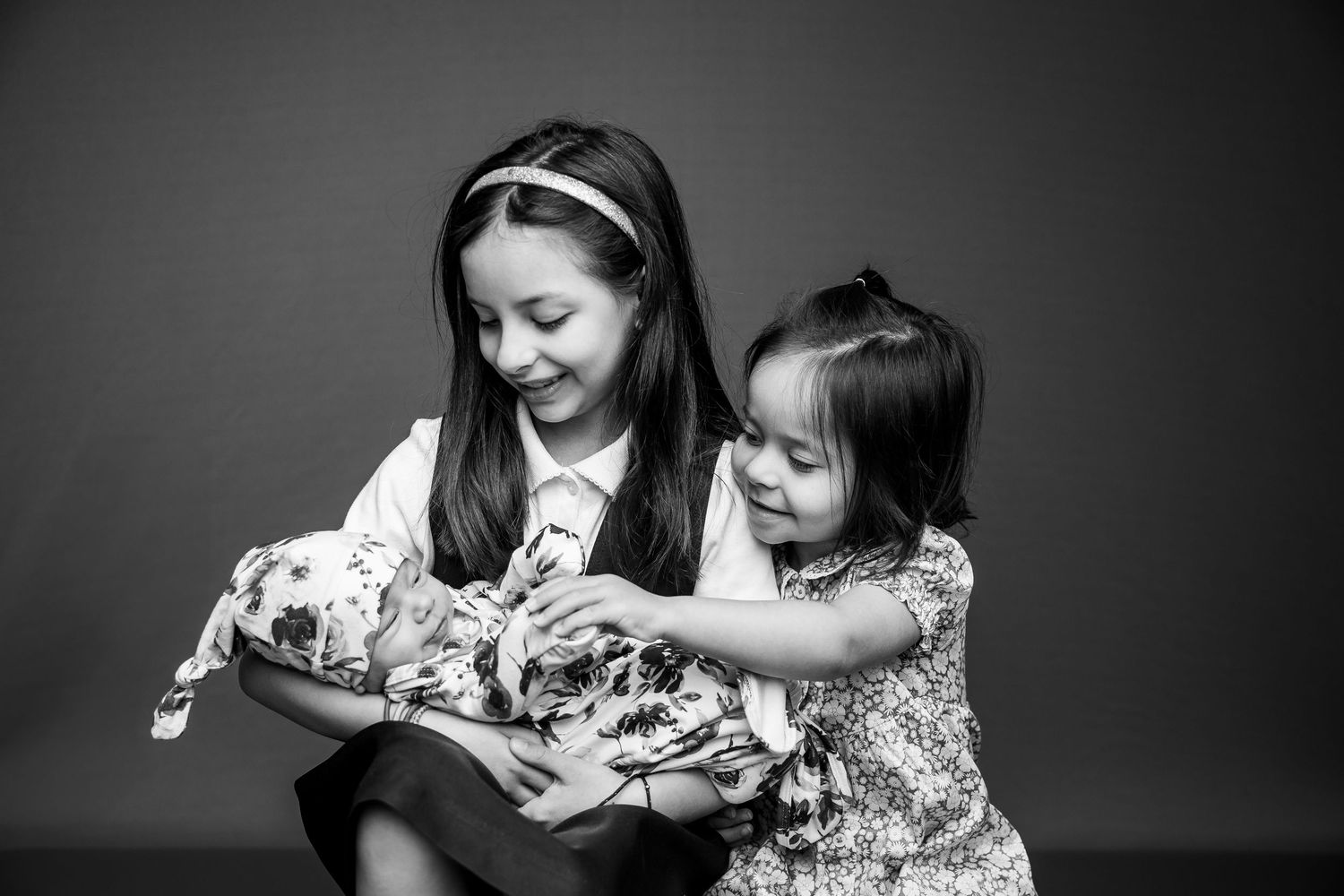 A tender black and white photo sequence showing simple gestures of affection between two people wearing floral clothing.