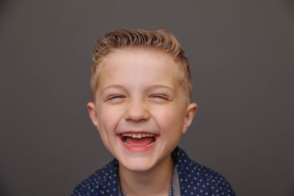 A collage of joyful expressions and laughter against a dark studio backdrop.