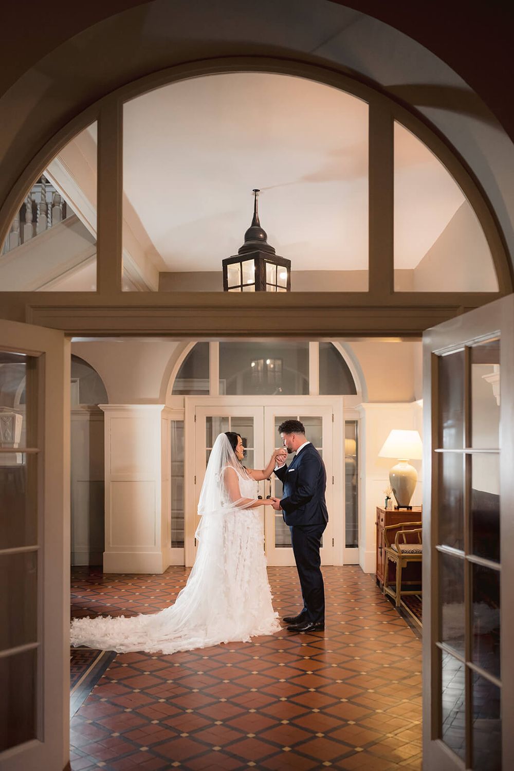 Wedding the first look in elegant venue with arched doorways and ornate architectural details. Belle Isle castle.