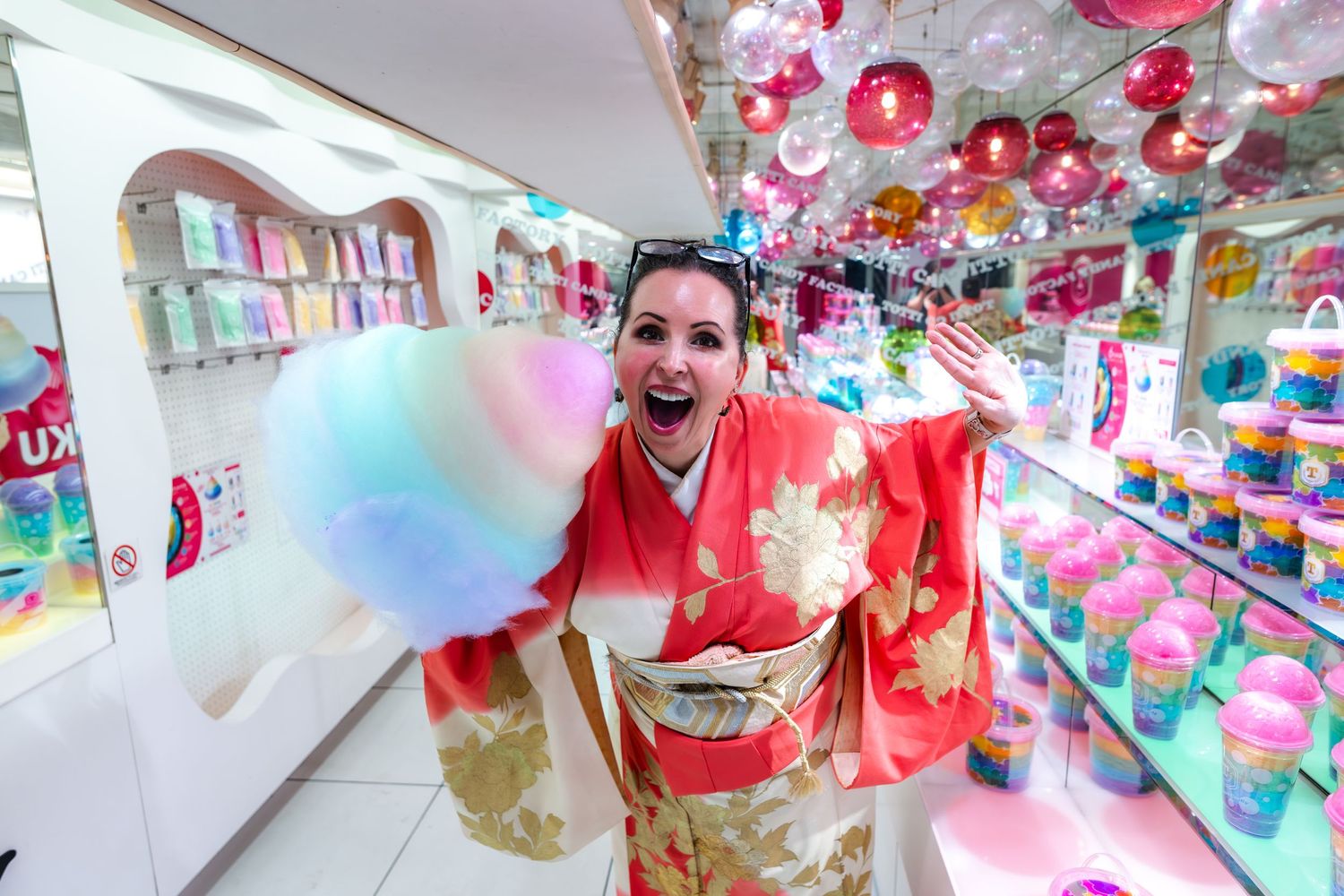 Festive scene inside a Japanese candy store with colorful cotton candy and hanging decorations in pink and red colors.