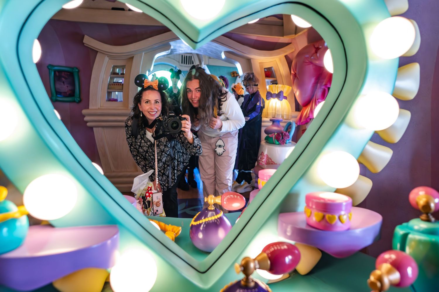 A vibrant scene viewed through a turquoise heart-shaped frame with colorful toys and decor in the foreground.