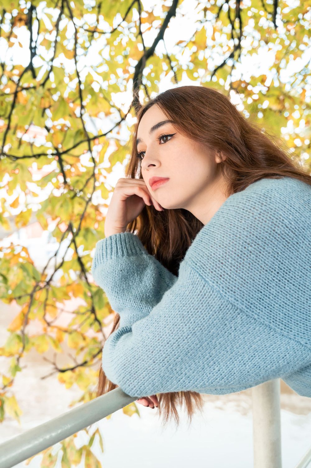 À Namur, près de la Citadelle, portrait d’une femme photographiée en automne près d’une barrière et d’un arbre lors d’une séance photo en ex