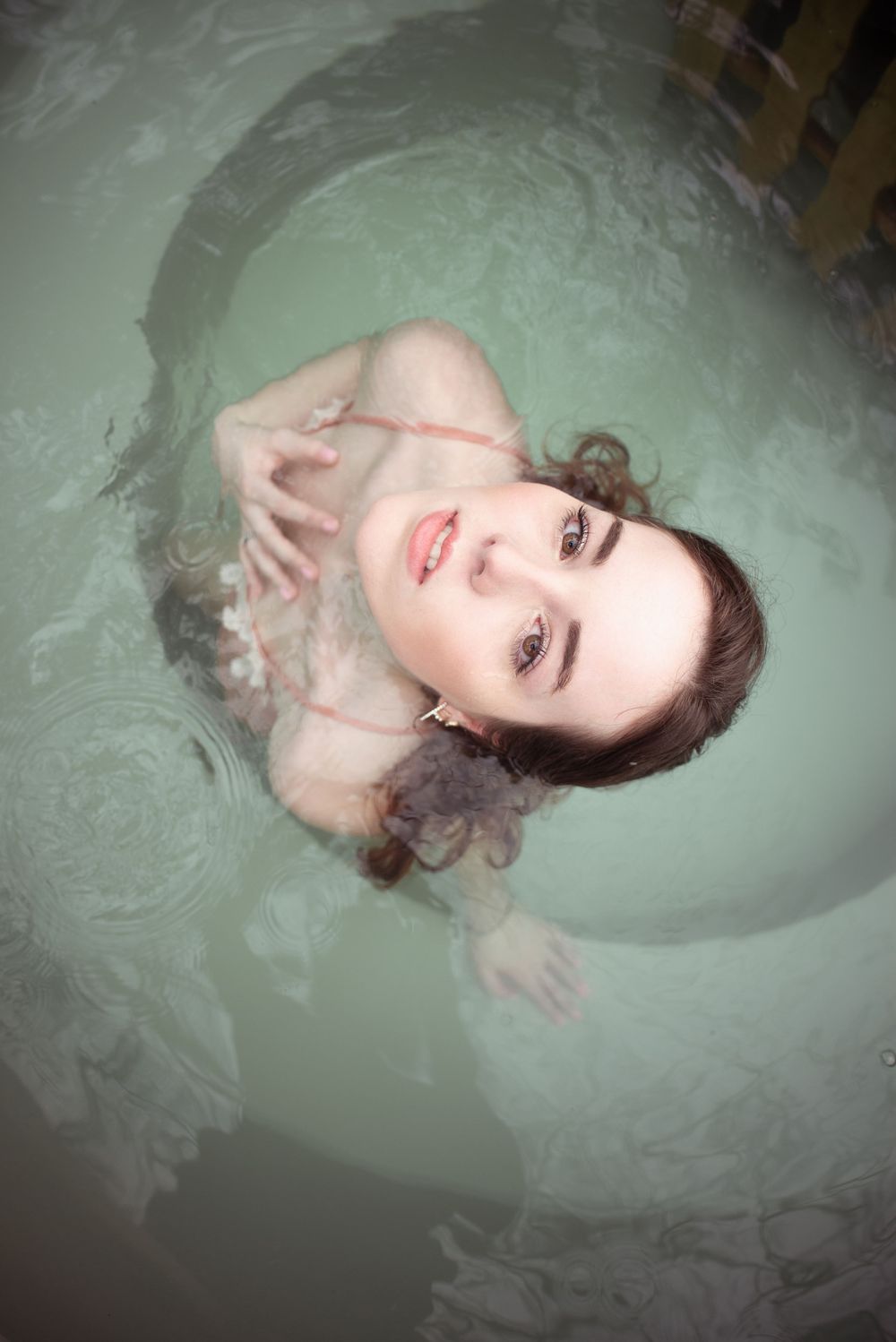 À Erezée, portrait individuel d’une femme photographiée en vue plongeante dans une baignoire nordique au chalet Cosy Night