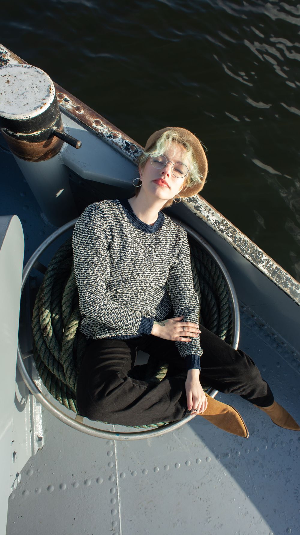 À Herstal, portrait individuel d’une femme allongée sur un bateau au bord de l’eau lors d’une séance photo en extérieur