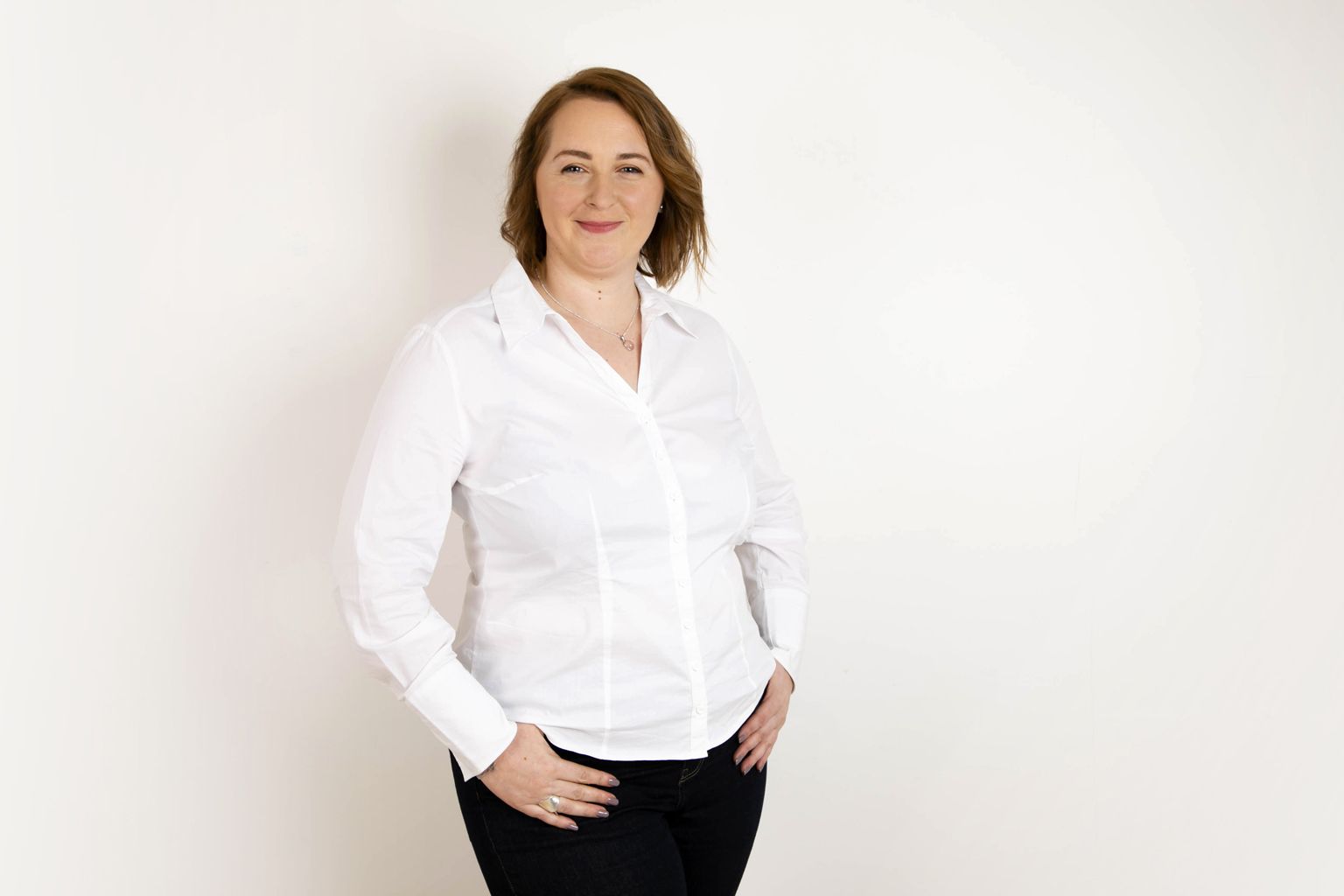 Portrait professionnel  d'une personne en chemise boutonnée blanche sur fond blanc.