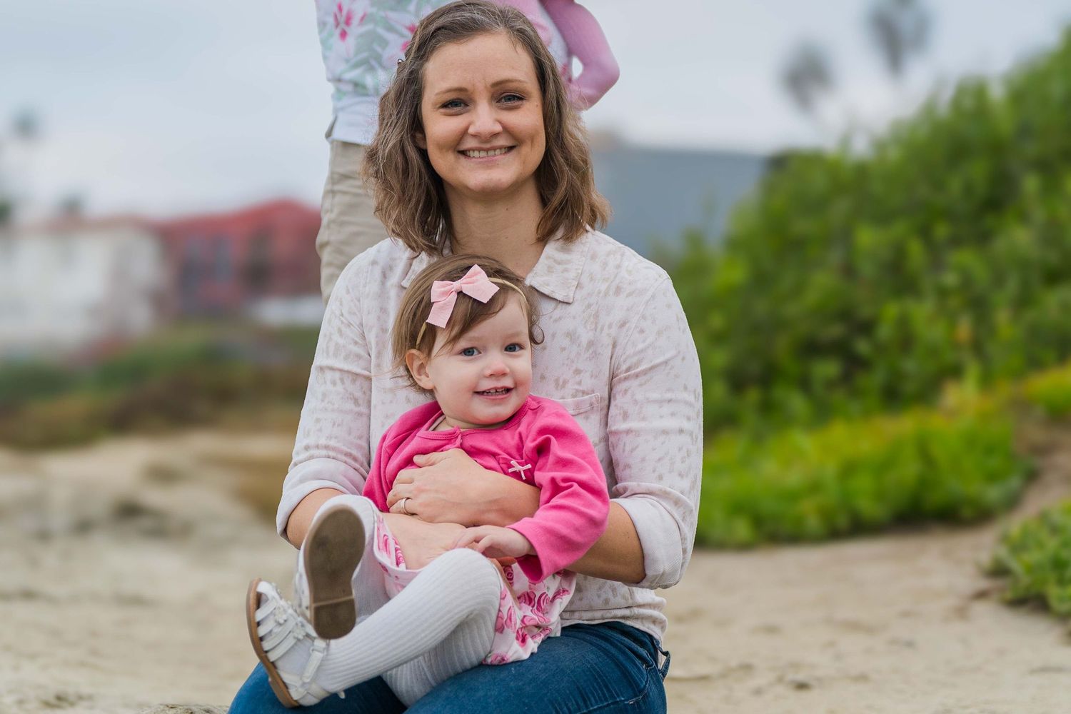 Family enjoying outdoor photography session on scenic coastal cliffs with ocean view.