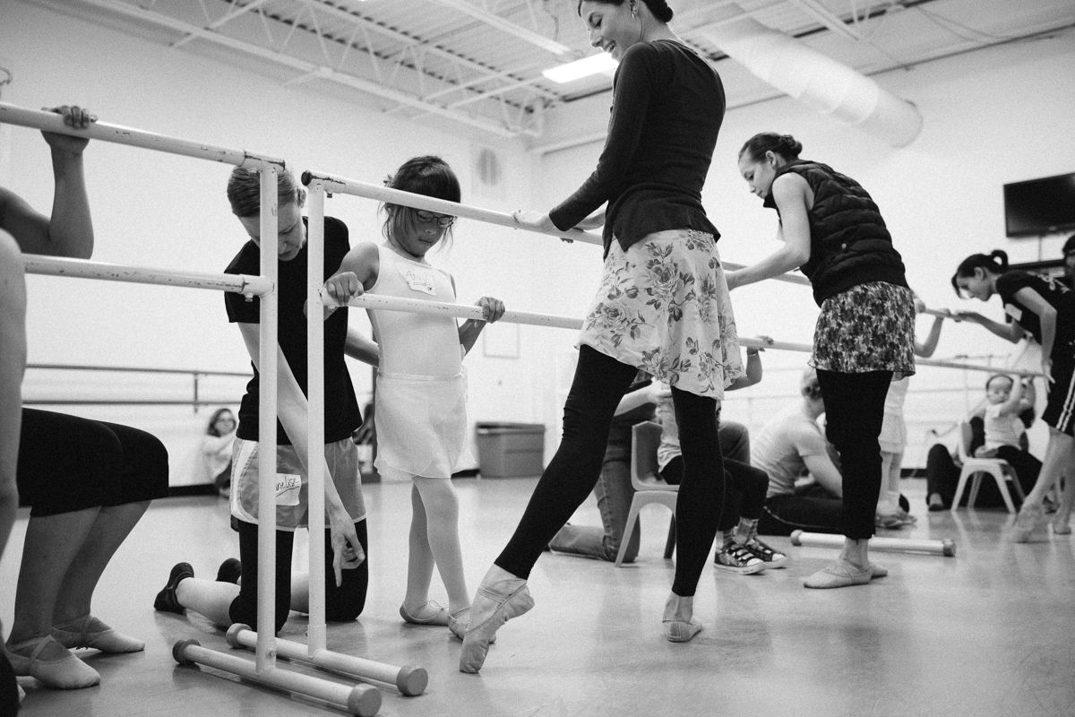 Dance students practicing at the barre during a ballet class.