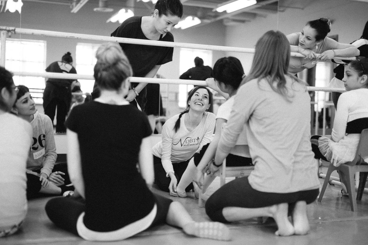 Dance students sitting in a circle during an interactive workshop session.