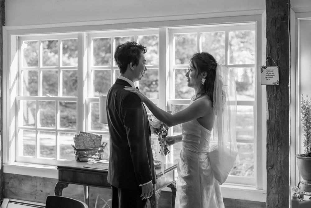 Intimate indoor wedding moment captured in silhouette by large windows.