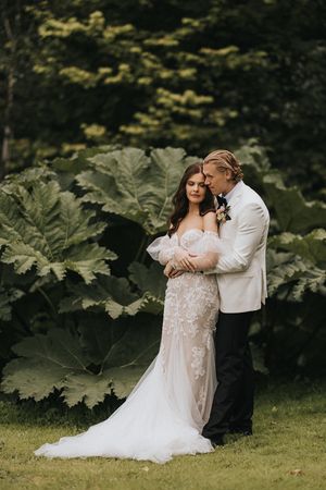 A romantic wedding photo session among giant green leaves in a garden setting at Askham Hall.