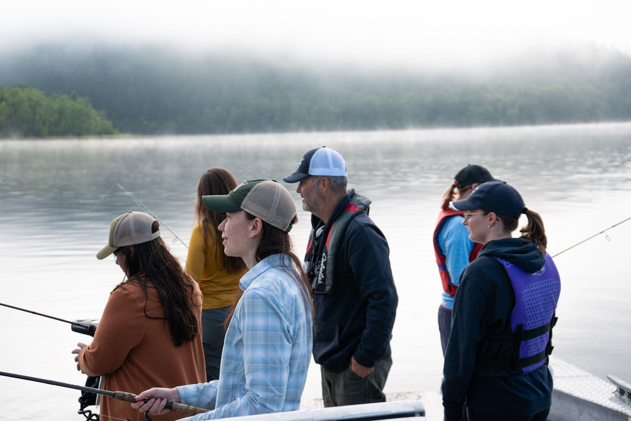 Fishing group on a boat during a misty morning on the lake.