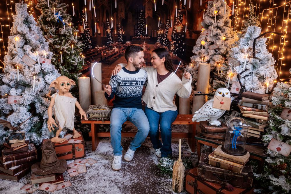 Enchanting holiday photo setting with snow-covered trees and warm glowing lights.