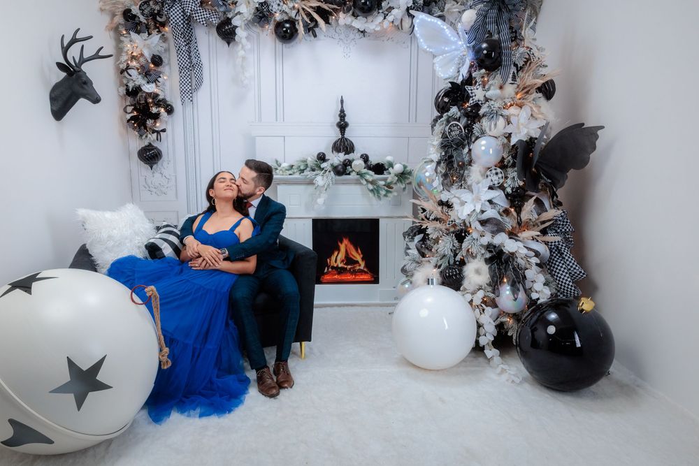 Romantic moment captured against silver and black holiday decorations with star balloons.