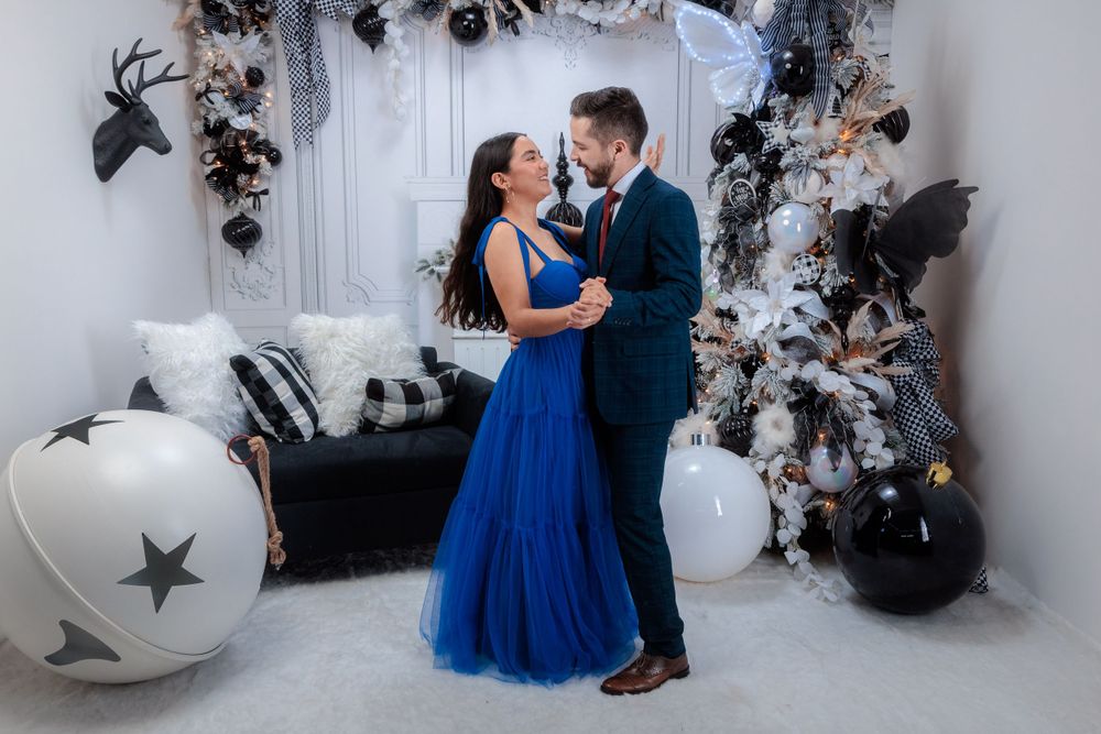 Couple shares an intimate dance moment surrounded by elegant winter party decorations.