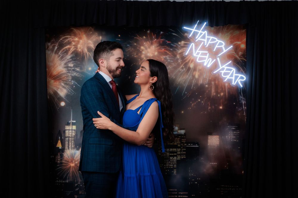 Couple dances beneath neon lighting at an elegant evening celebration.