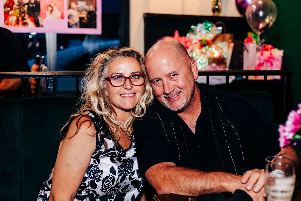 Couple smiling together at a party with pink decorations and balloons at an event in lake worth.