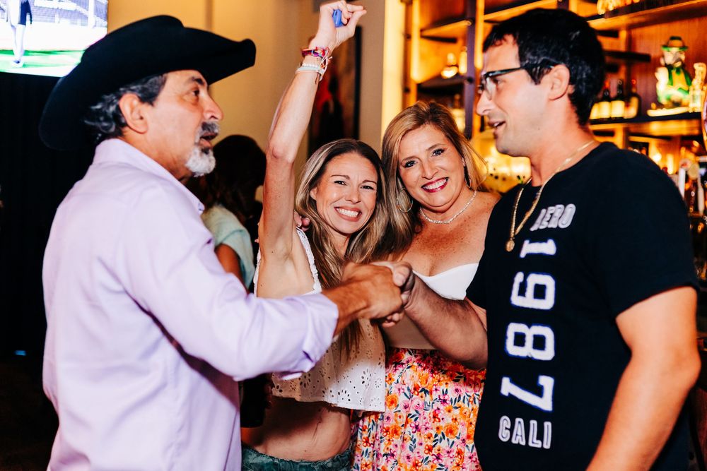 Group celebrating energetically at a bar with animated expressions and gestures at an event in lake worth.