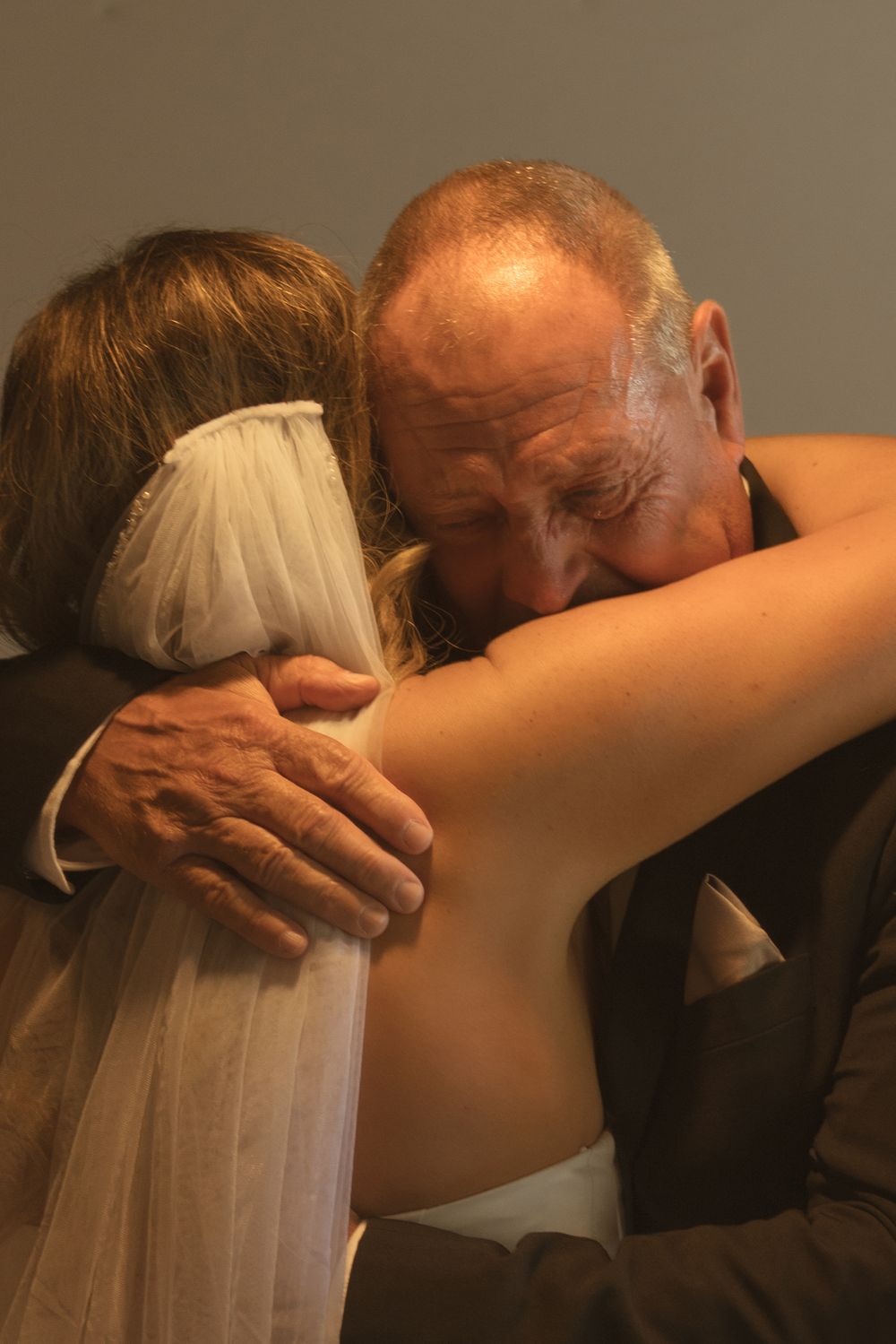 Emotional sequence showing tender embrace between family members at wedding.