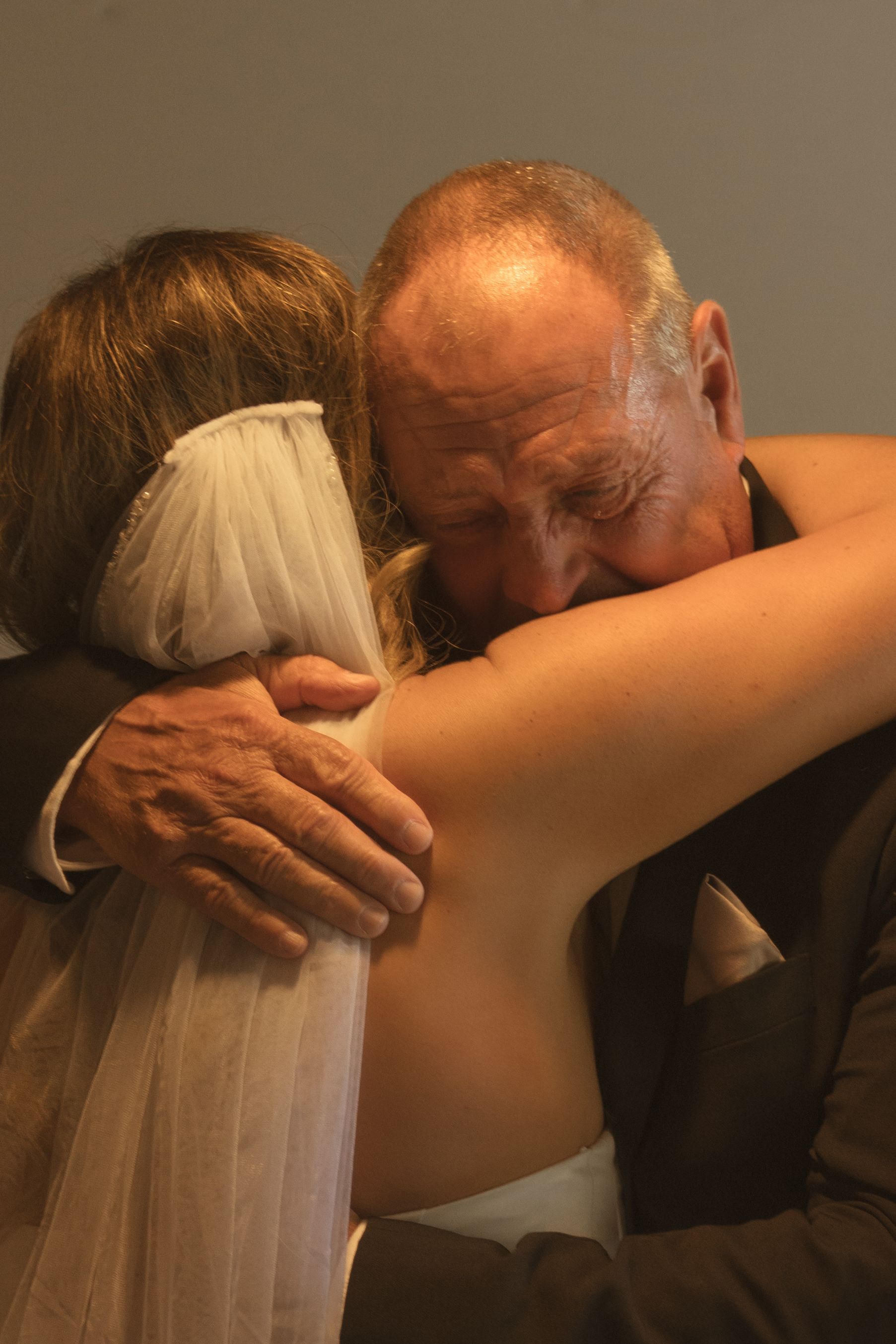 Emotional sequence showing tender embrace between family members at wedding.
