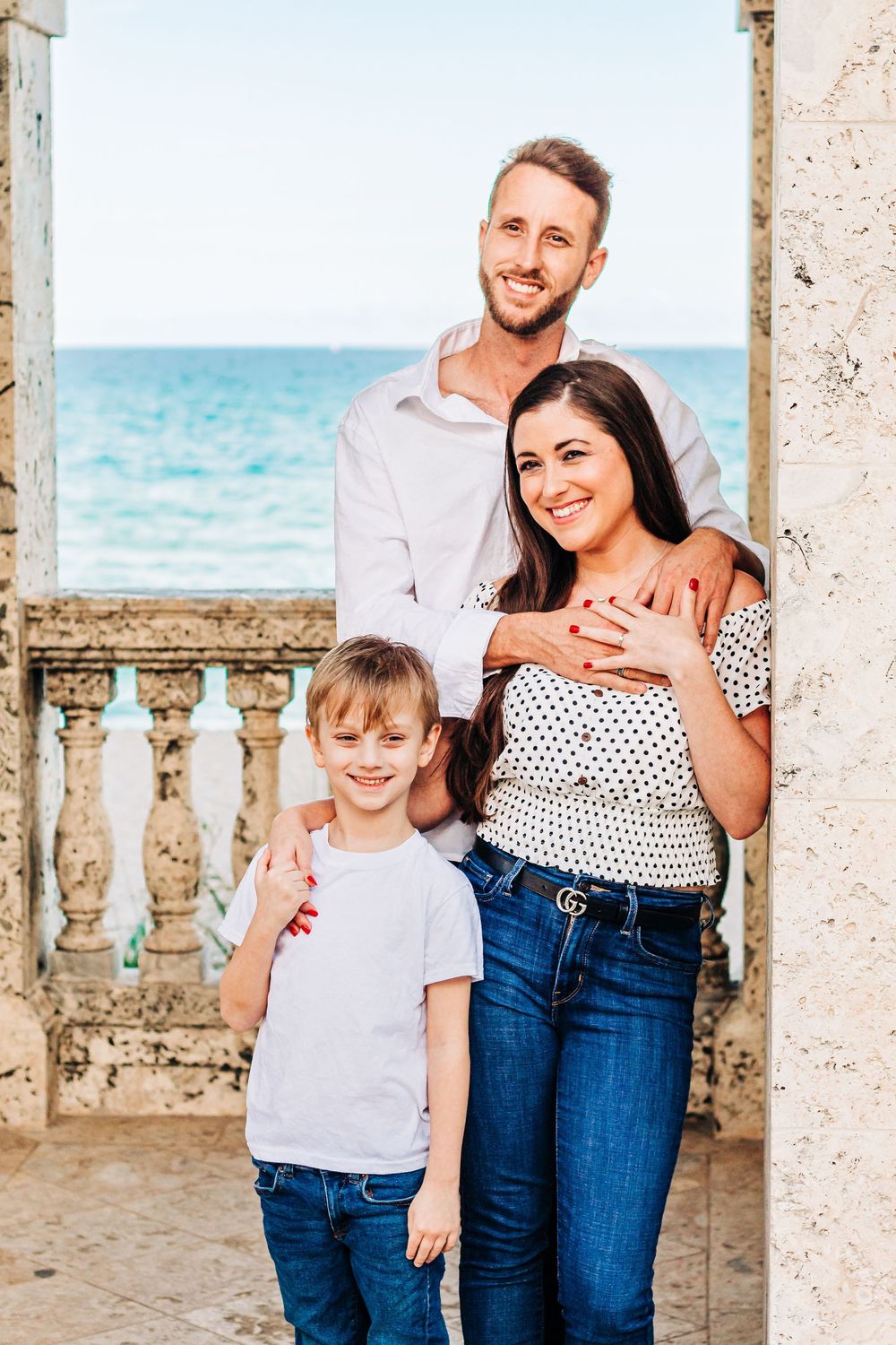 Family portrait by ocean balcony with coastal views in background, worth ave palm beach Florida in palm beach Florida on the clock tower.
