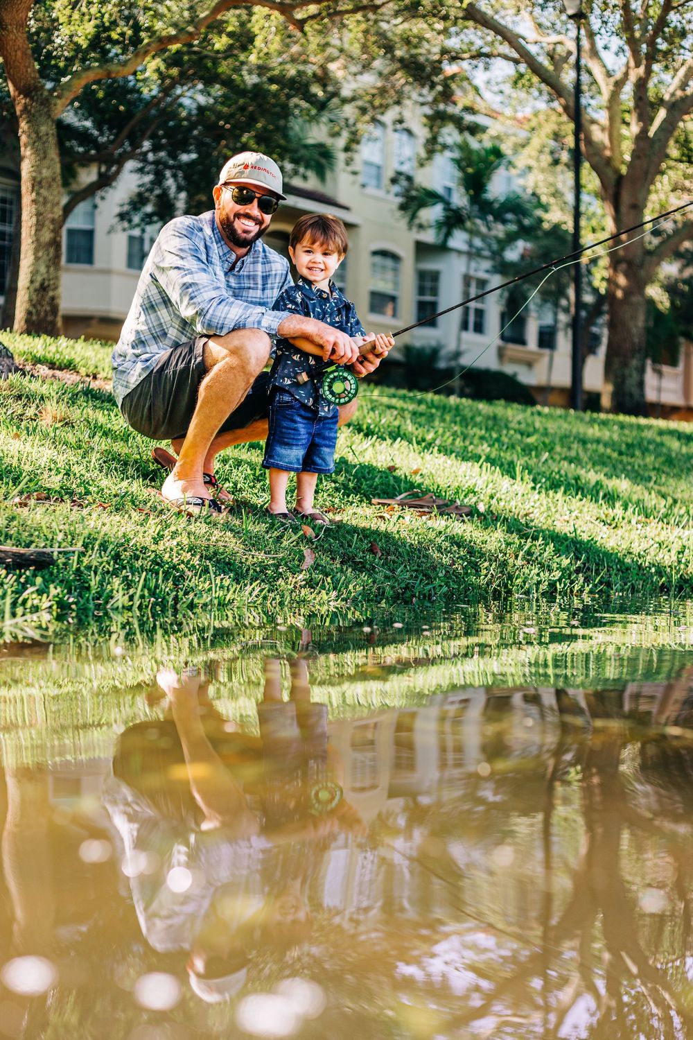 A fishing scene by a pond with reflections in the water on a sunny day home session