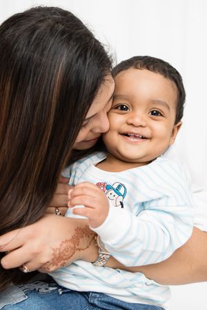 Sweet intimate portrait showing tender affection and joyful smile in light and bright studio setting.