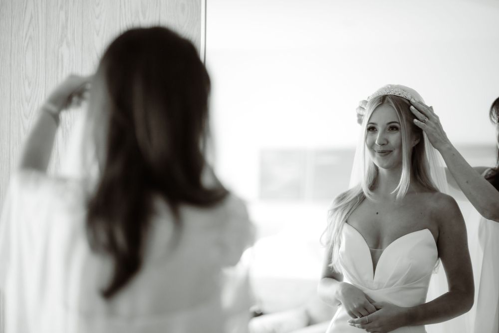 Black and white photo of a bride in a sweetheart neckline dress during wedding preparations.