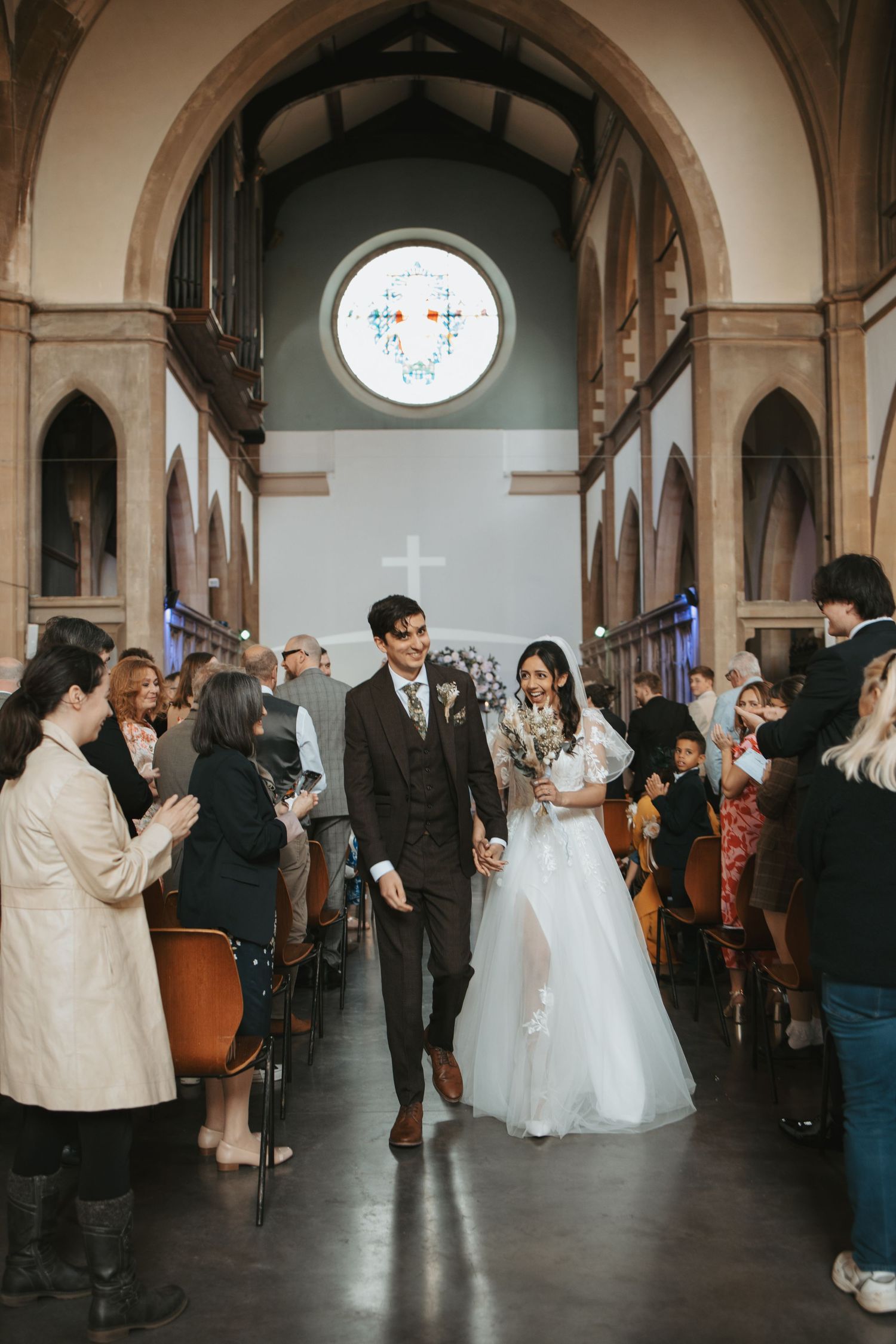 Wedding celebration inside a beautiful church with guests watching the couple dance.