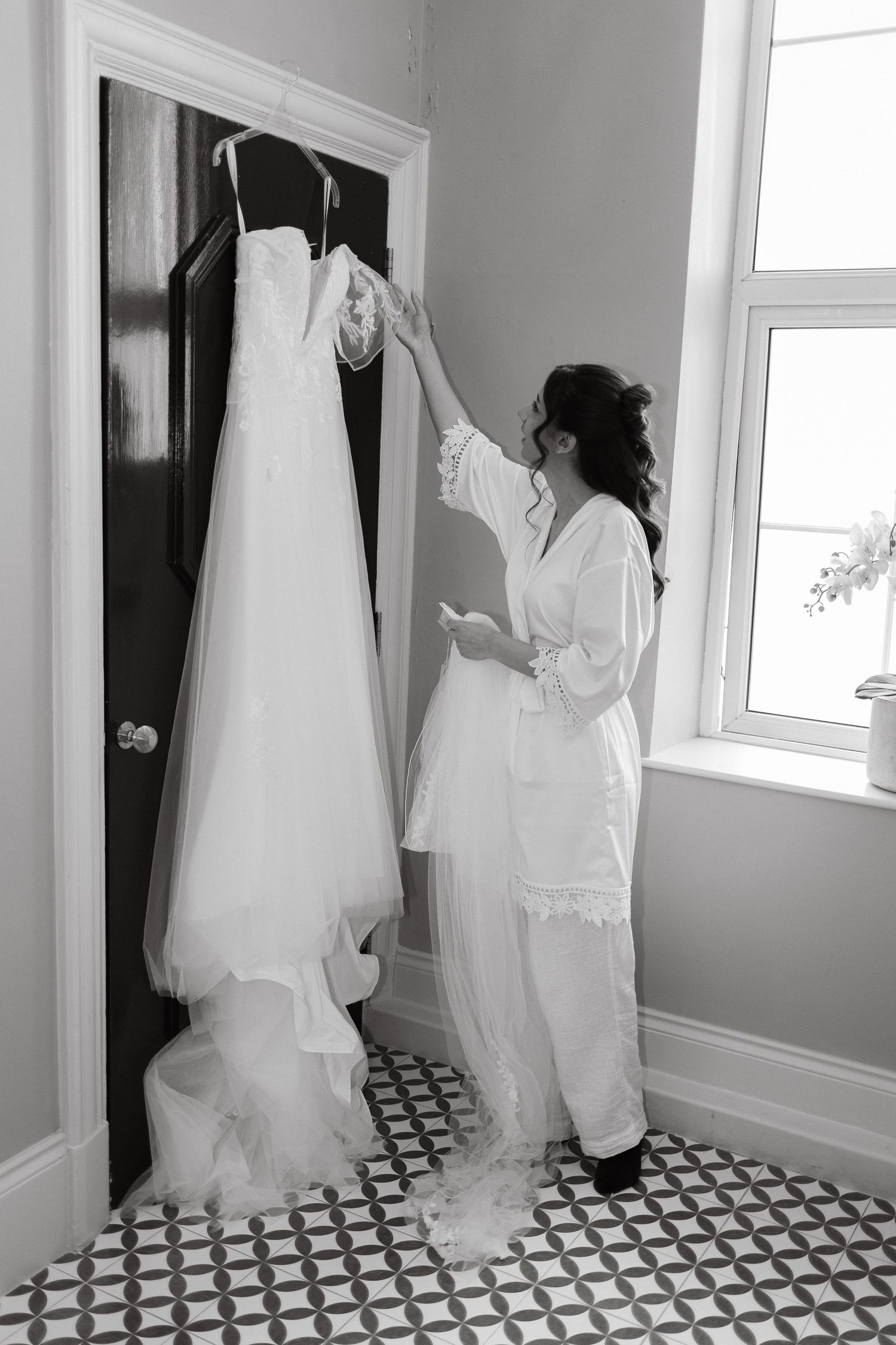 Black and white sequence of wedding dress preparation in room with checkered floor.