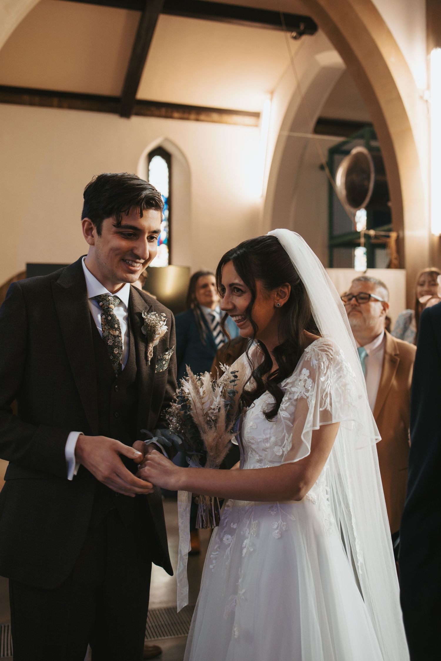 A romantic wedding ceremony moment captured in a church with beautiful arched architecture.