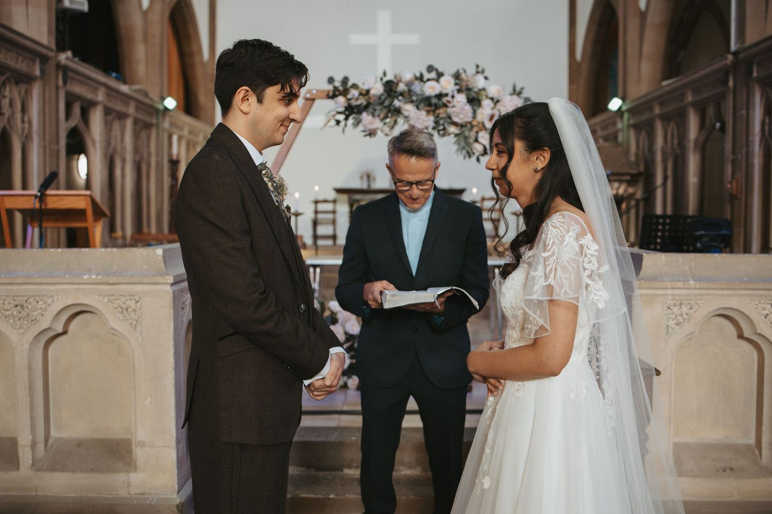 An intimate wedding ceremony moment captured at the altar of a historic church.