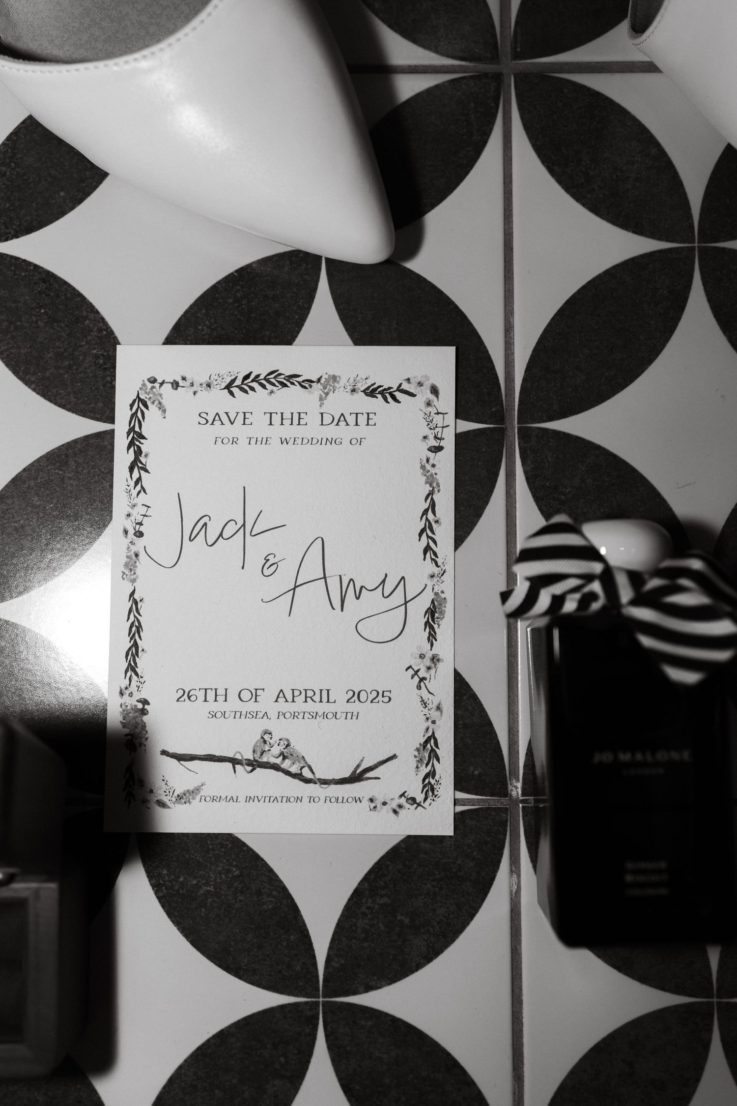 Save the date wedding invitation displayed on black and white geometric patterned background.