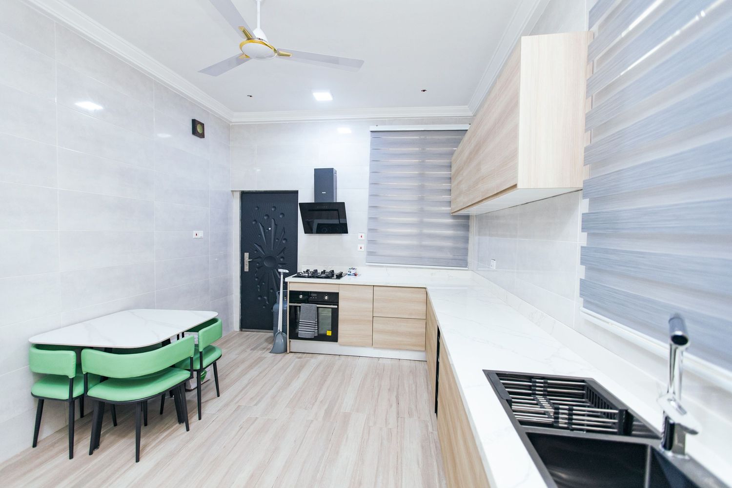 Clean modern room with white walls, ceiling fan, and green furniture accents.