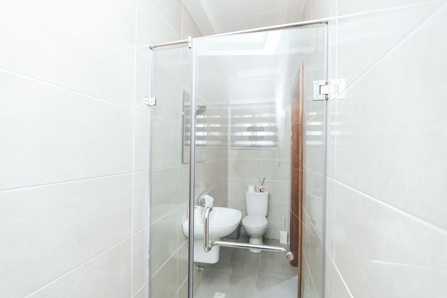 Contemporary white bathroom with glass shower enclosure and modern fixtures showcasing sleek minimalist design.