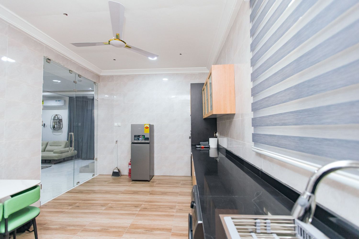 Spacious dining area with wooden floors, white walls, and modern window treatments.