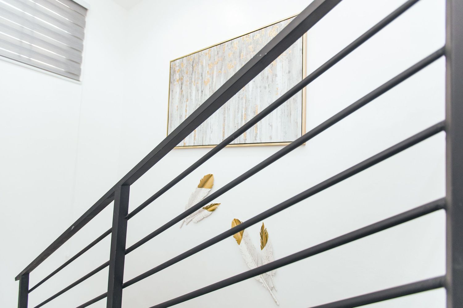 Black horizontal railings against a white wall creating a modern architectural detail.