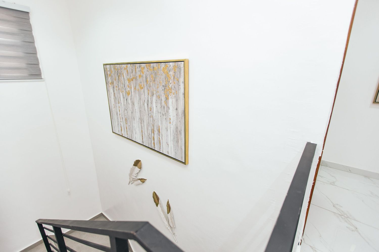 Minimalist white hallway with wooden accents and contemporary wall decor.