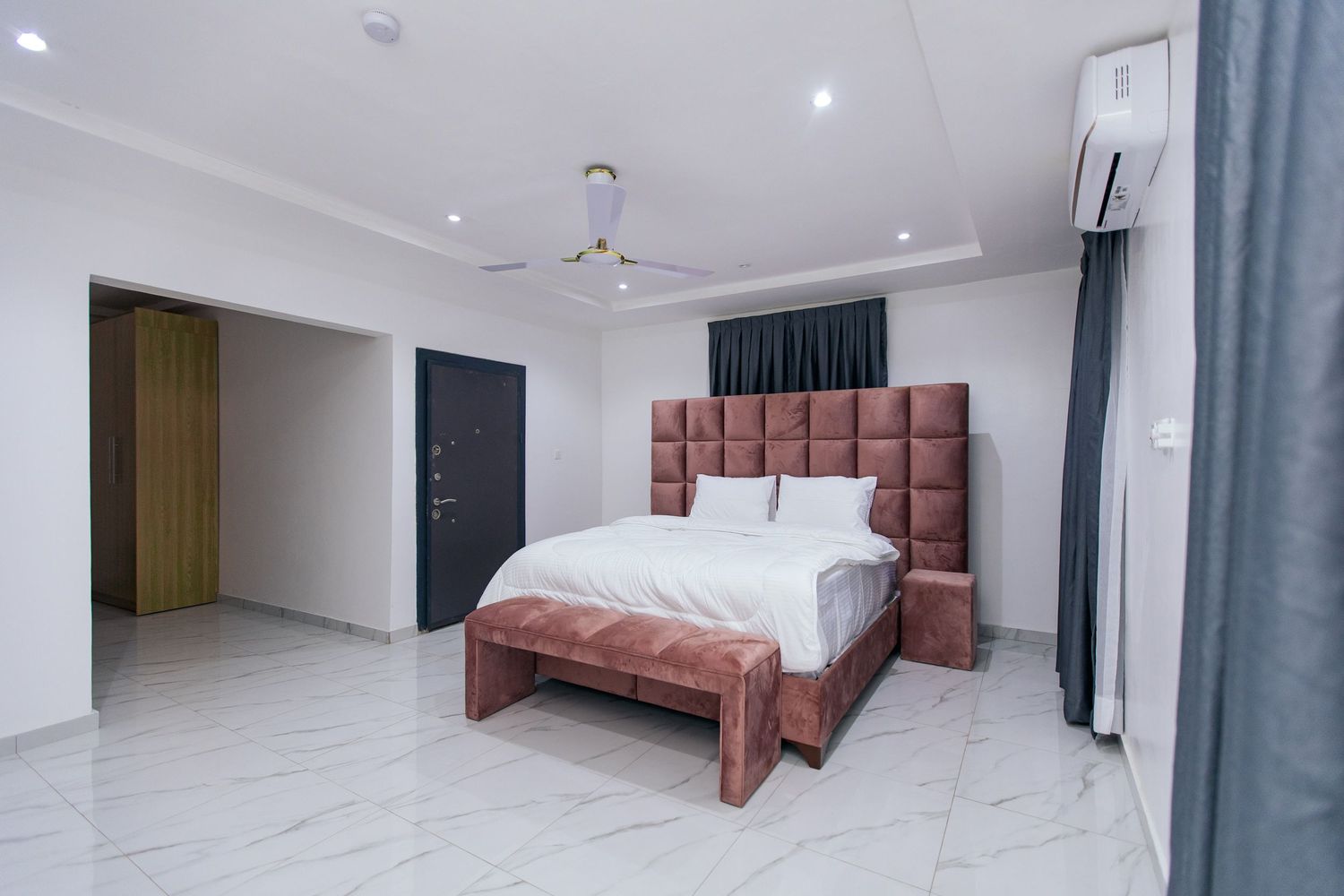 Clean minimalist bedroom with recessed lighting and contemporary furniture design.