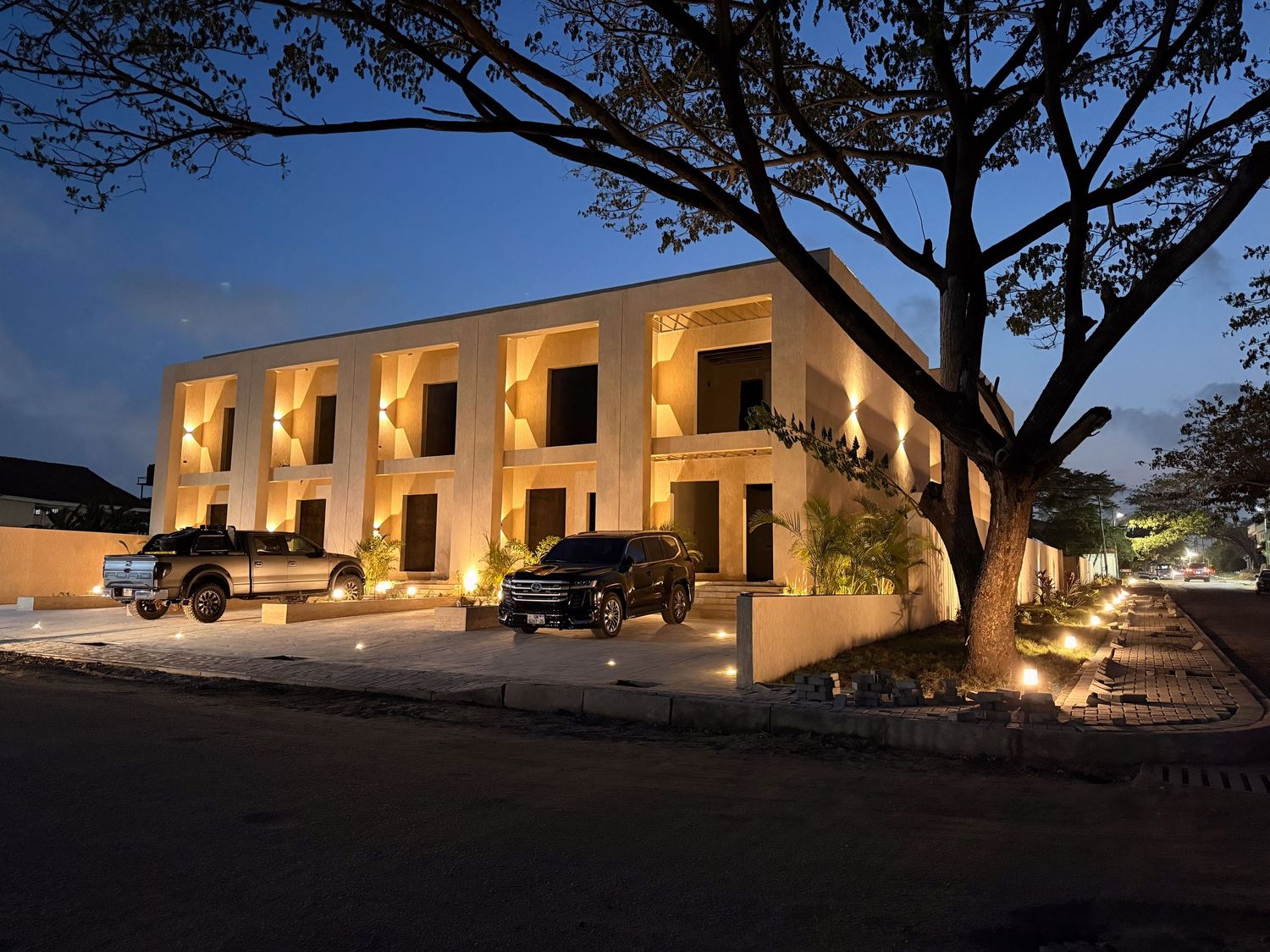 Panoramic view of illuminated Spanish colonial style building with arched portico at dusk.