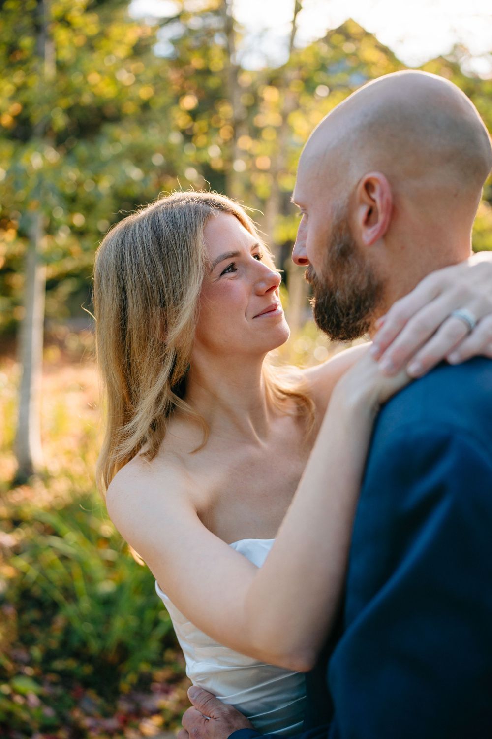 A romantic sequence of a couple sharing tender kisses in a golden sunset with trees in the background.