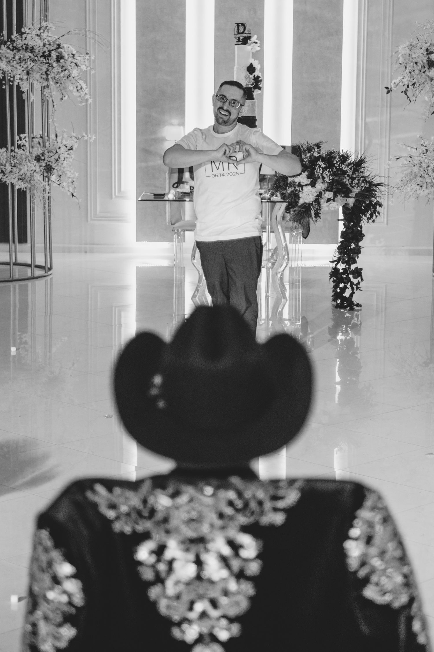A series of black and white photographs showing silhouettes against a bright interior hallway with floral arrangements.